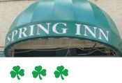 A green awning with the word spring inn on it