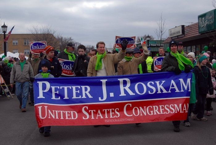 A group of people holding a banner that says peter j. roskam united states congressman