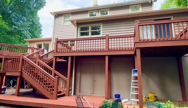 Empty living room with dark gray walls, hardwood floors, fireplace, built-in shelves, and double doors.