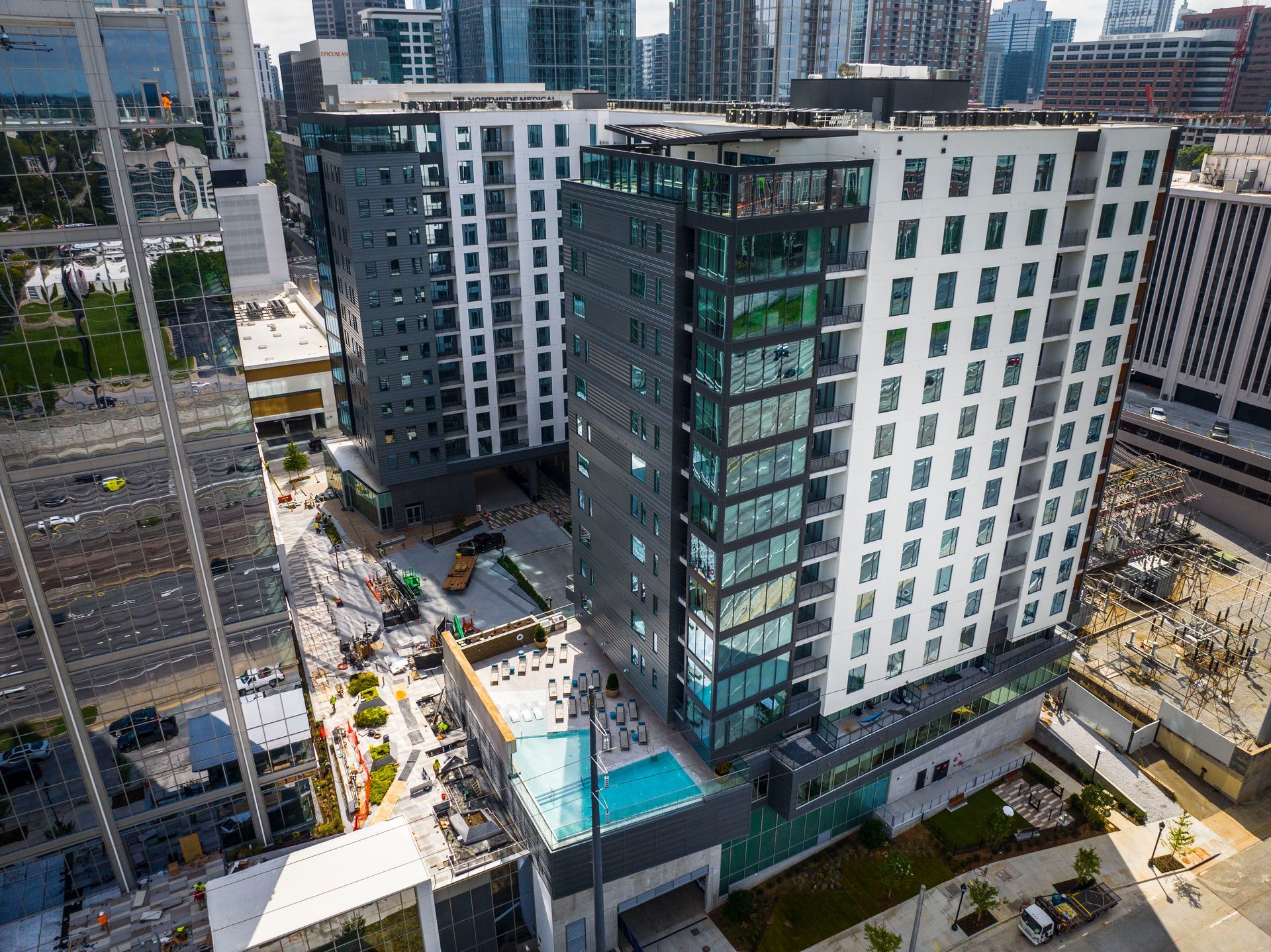 Woman on a couch with a small dog. Home interior with framed photos in the background.