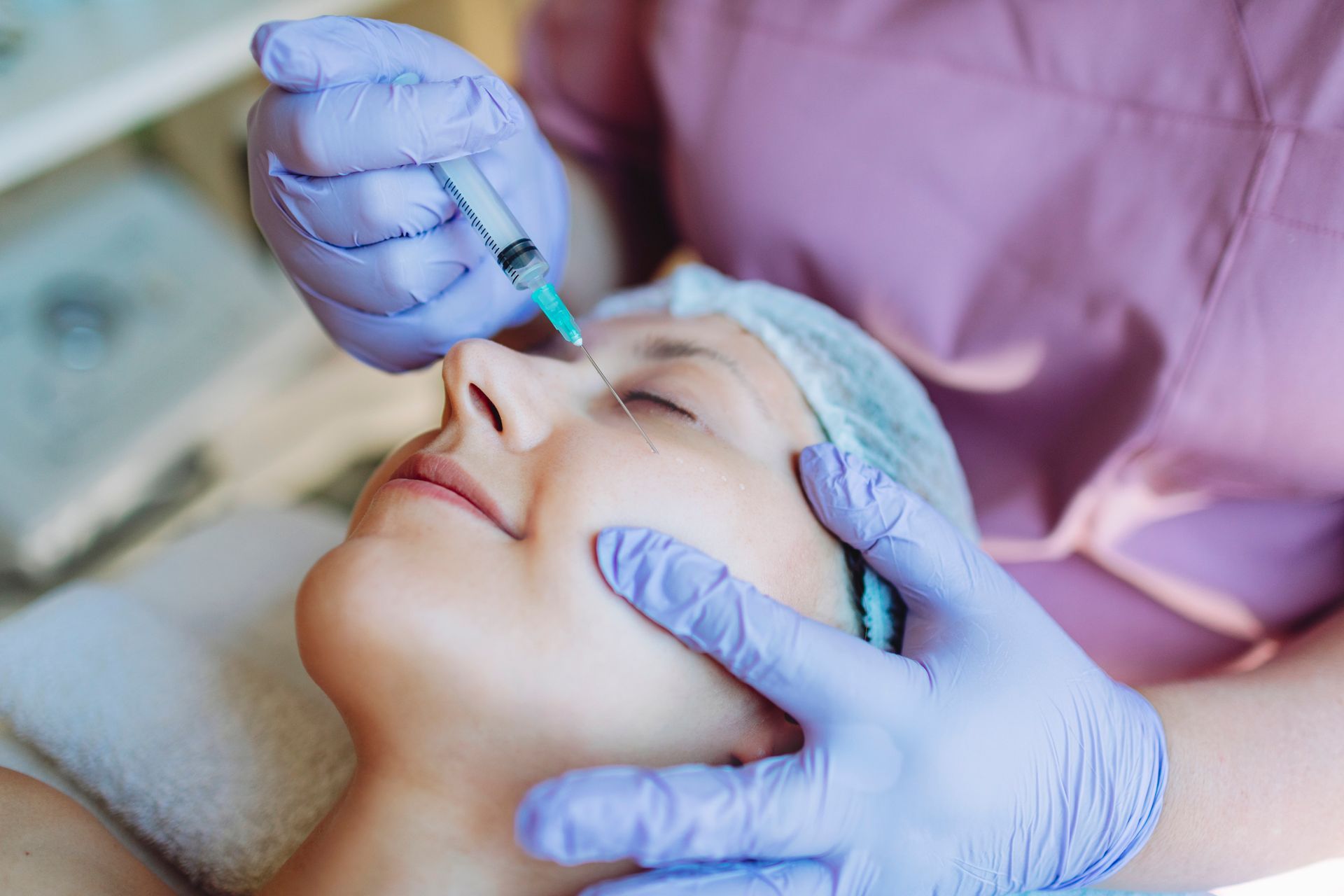 A woman receiving a botox injection in her face, focusing on her expression during the procedure. A woman receiving a botox injection in her face, focusing on her expression during the procedure.