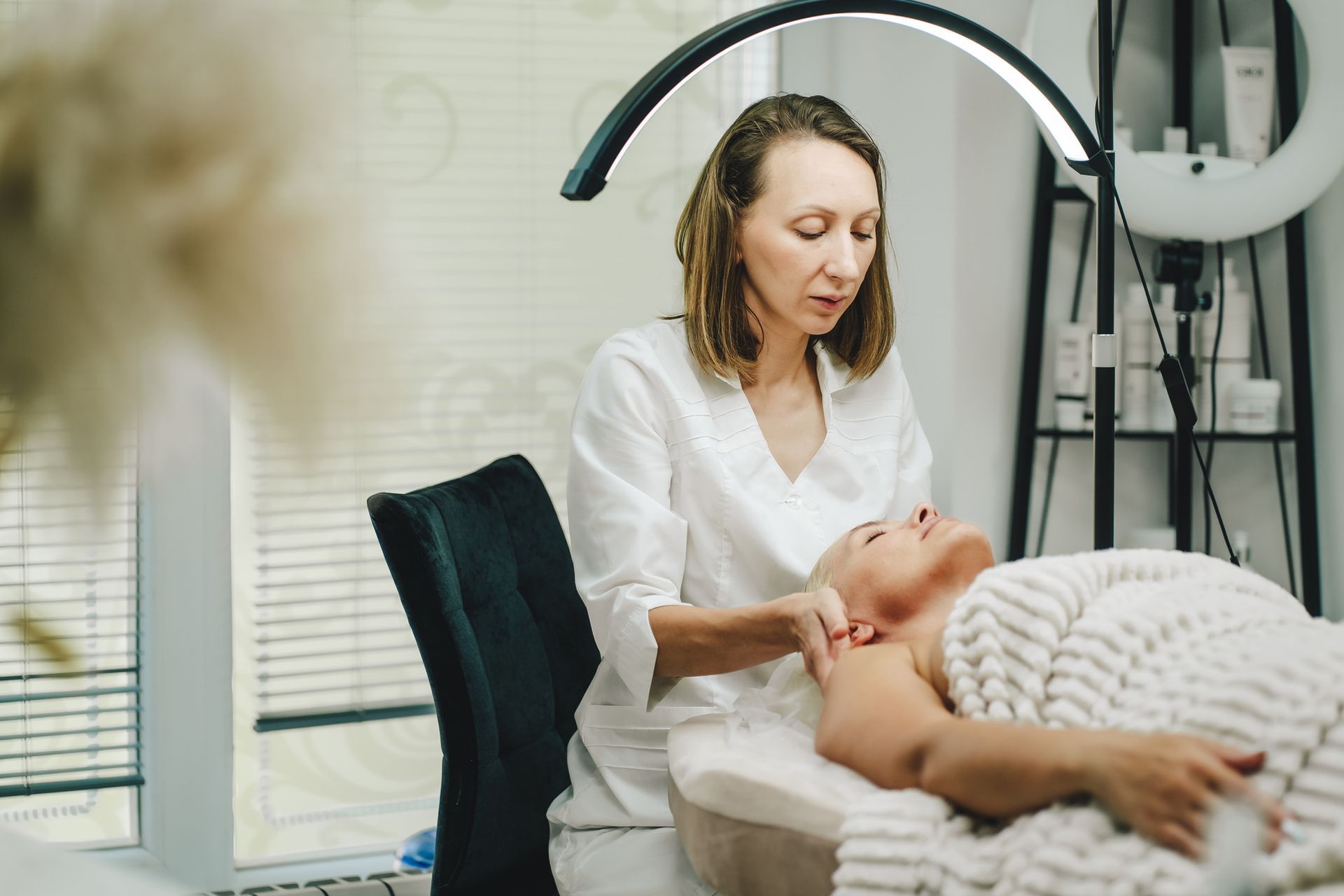 Person receiving a facial treatment under a ring light.