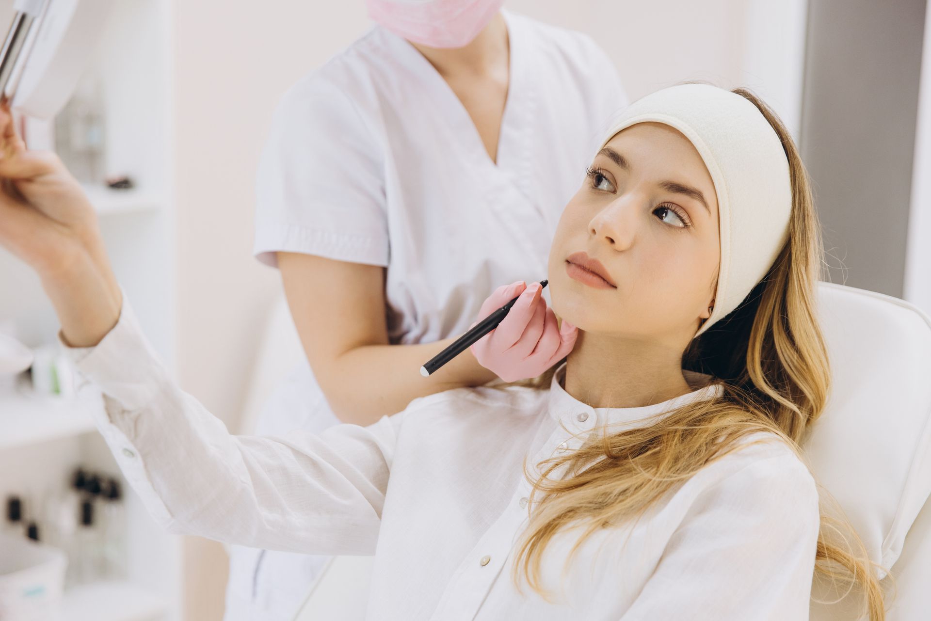 Person in a beauty clinic receiving a cosmetic procedure from a professional.