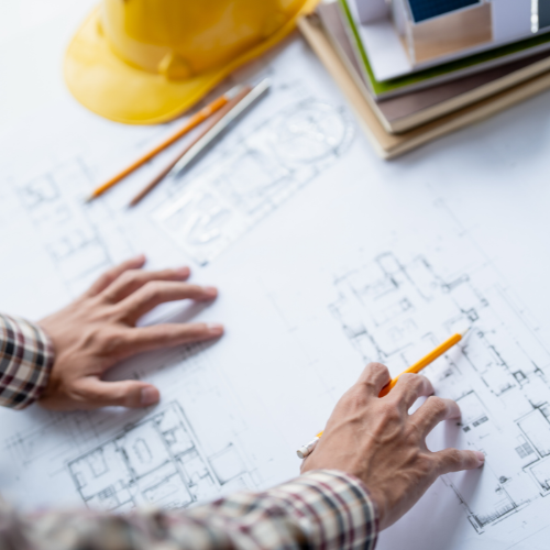 Silver electric SUV charging at a charging station with a black cable, outdoors.