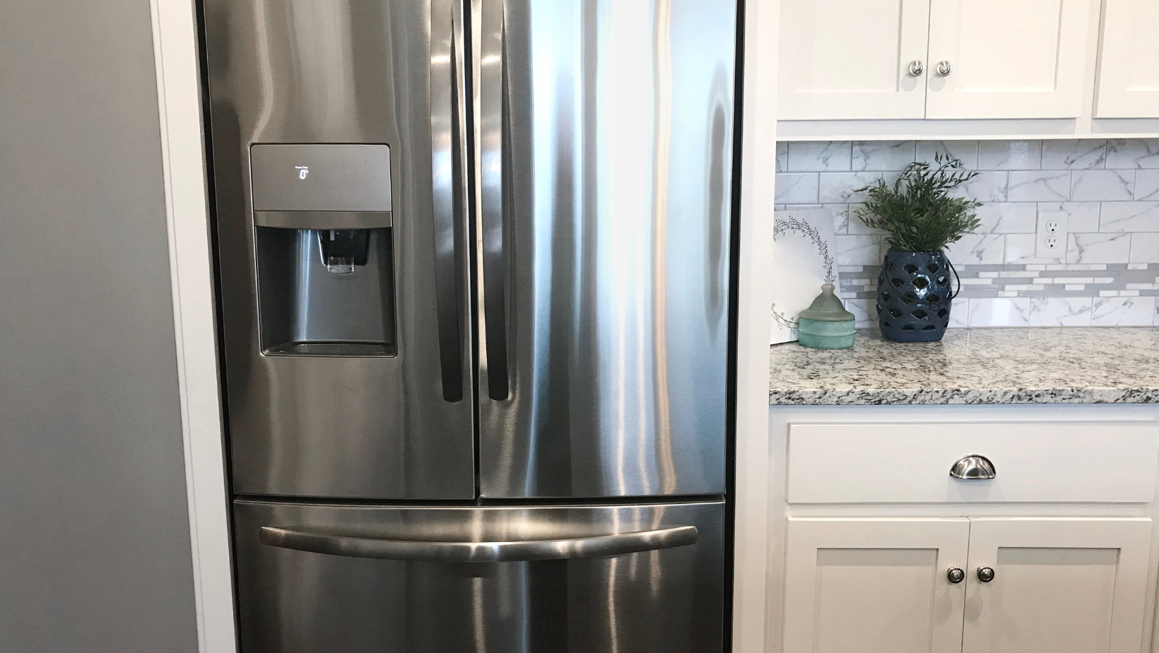 A stainless steel refrigerator is sitting in a kitchen next to a counter.