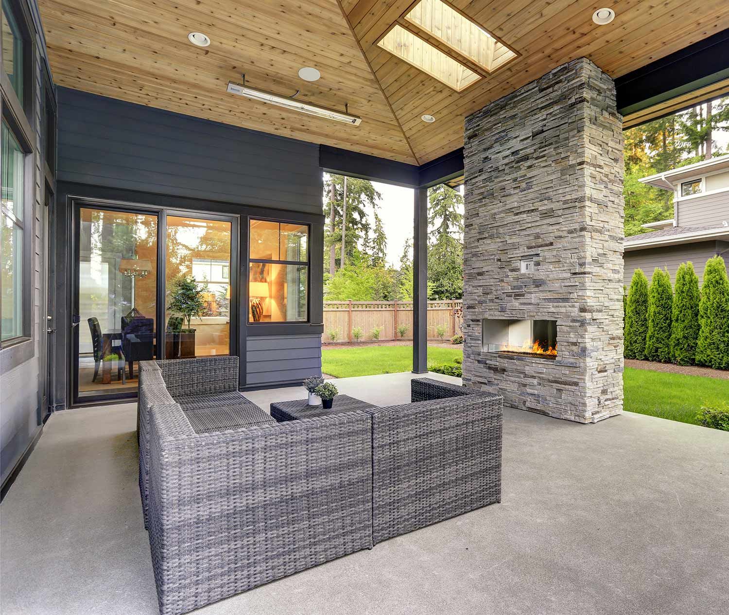 A modern covered patio with a stone fireplace