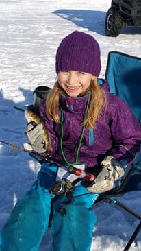 Girl kneeling with her chocolate lab in the snow