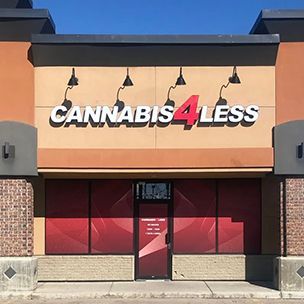 Cannabis 4 Less store exterior with sign in front of a blue sky.
