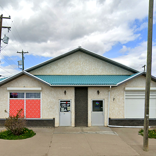 Jar of cannabis buds spilling onto a black surface.