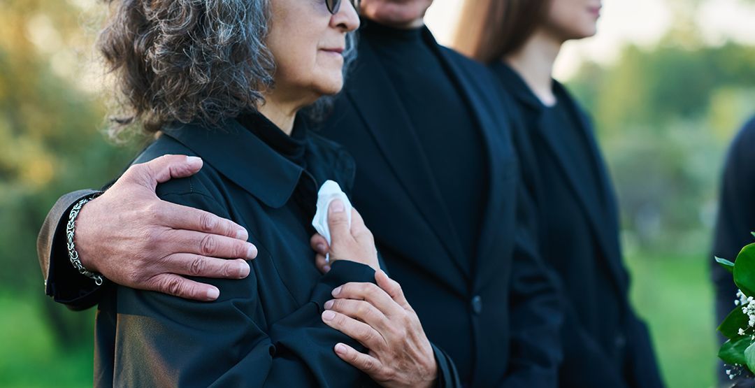 a man is hugging a woman at a funeral .