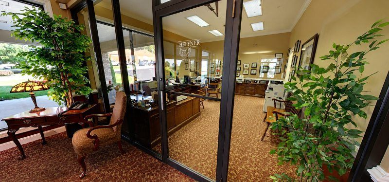 Modern funeral home office interior with glass entry doors, desks, seating, plants, Dallastown, PA Funeral Home and Cremations