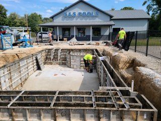 A swimming pool is being built in front of a building.
