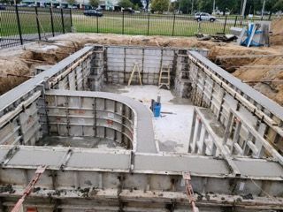 A large swimming pool is being built in a construction site.