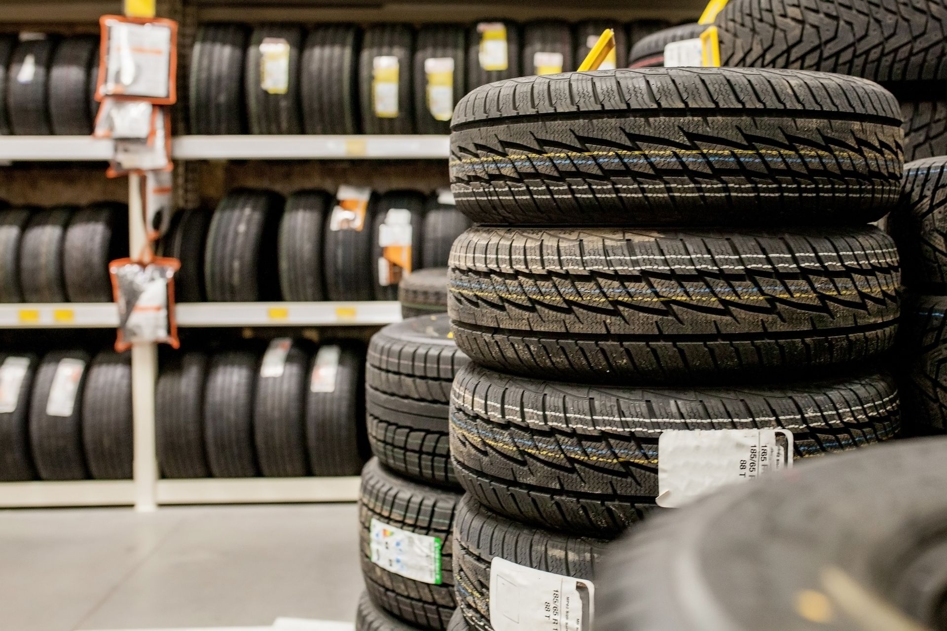 Car tires are stacked inside a warehouse.
