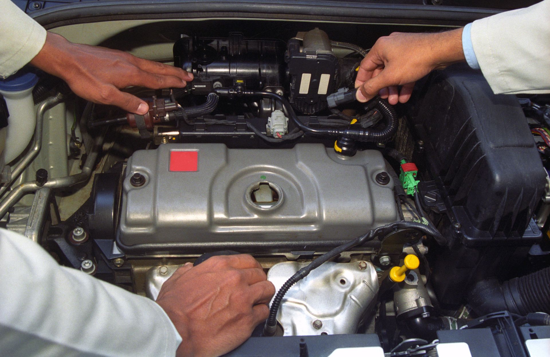 A mechanic checking the engine of a car, performing essential diagnostics for car repair services.