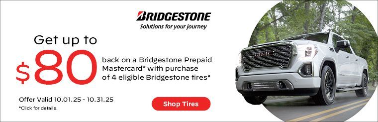 An ad for Bridgestone tires shows a silver car on the road.