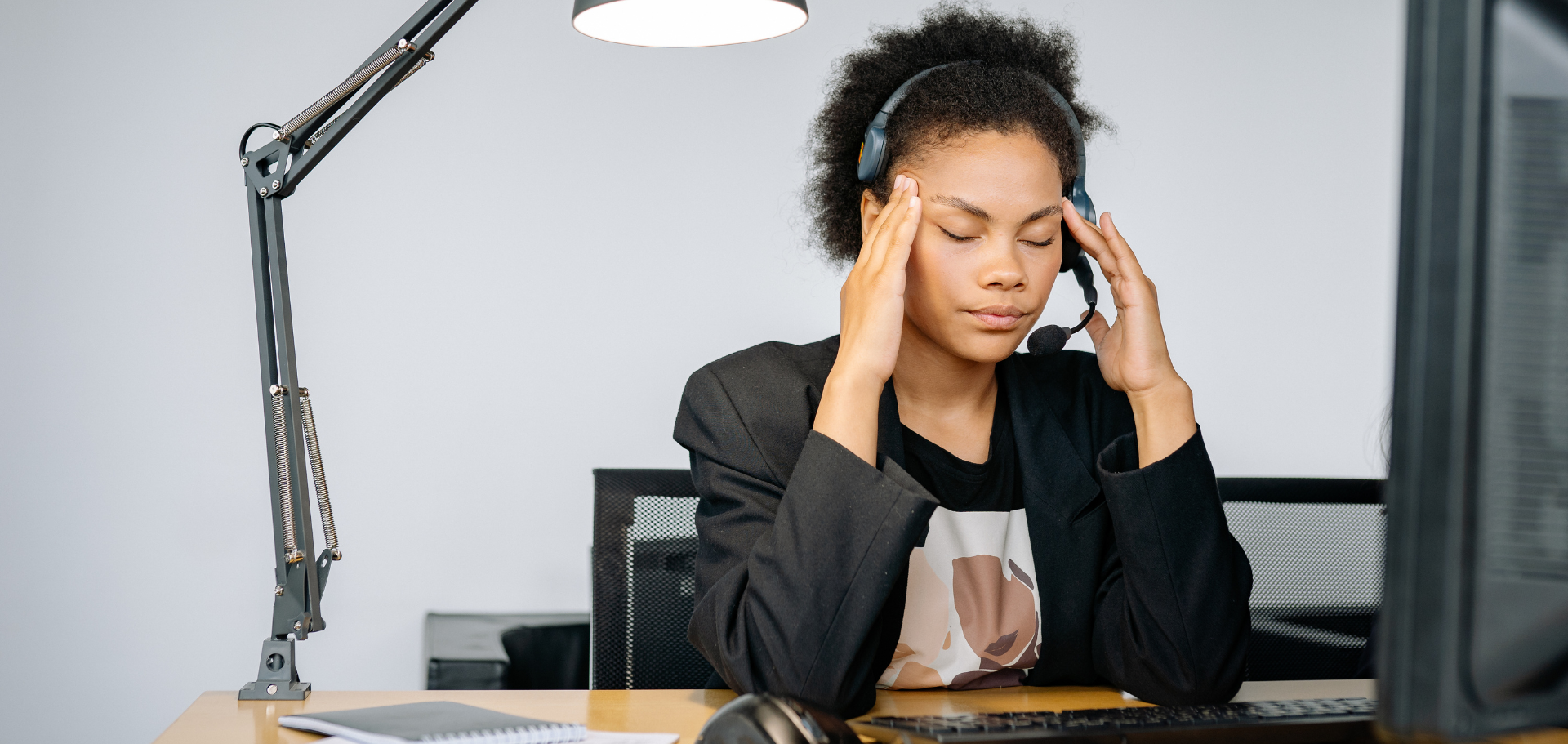 Vrouw zit vermoeid aan de keukentafel — symbool voor uitputting na een miskraam