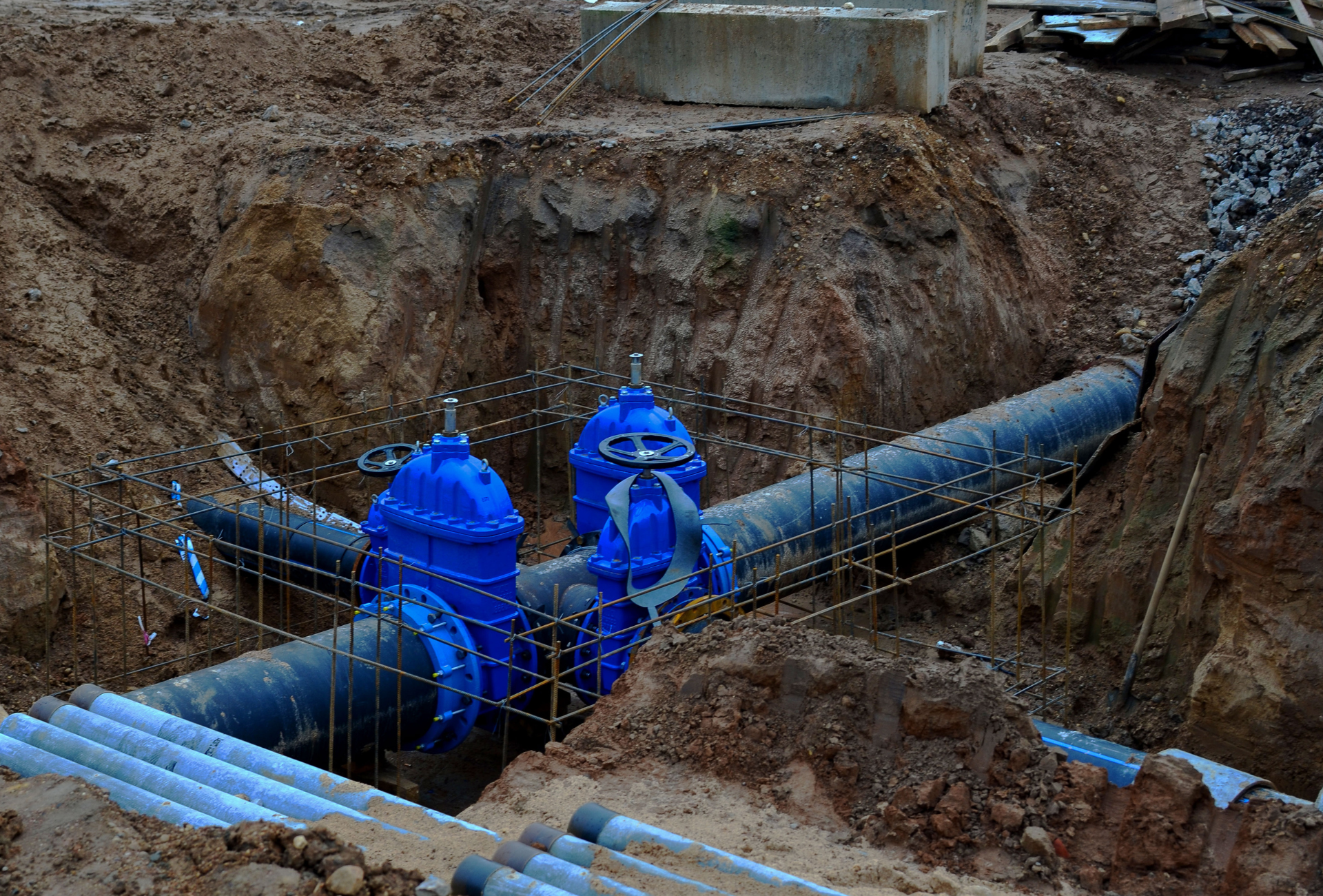 A concrete foundation is being built in a field with trees in the background