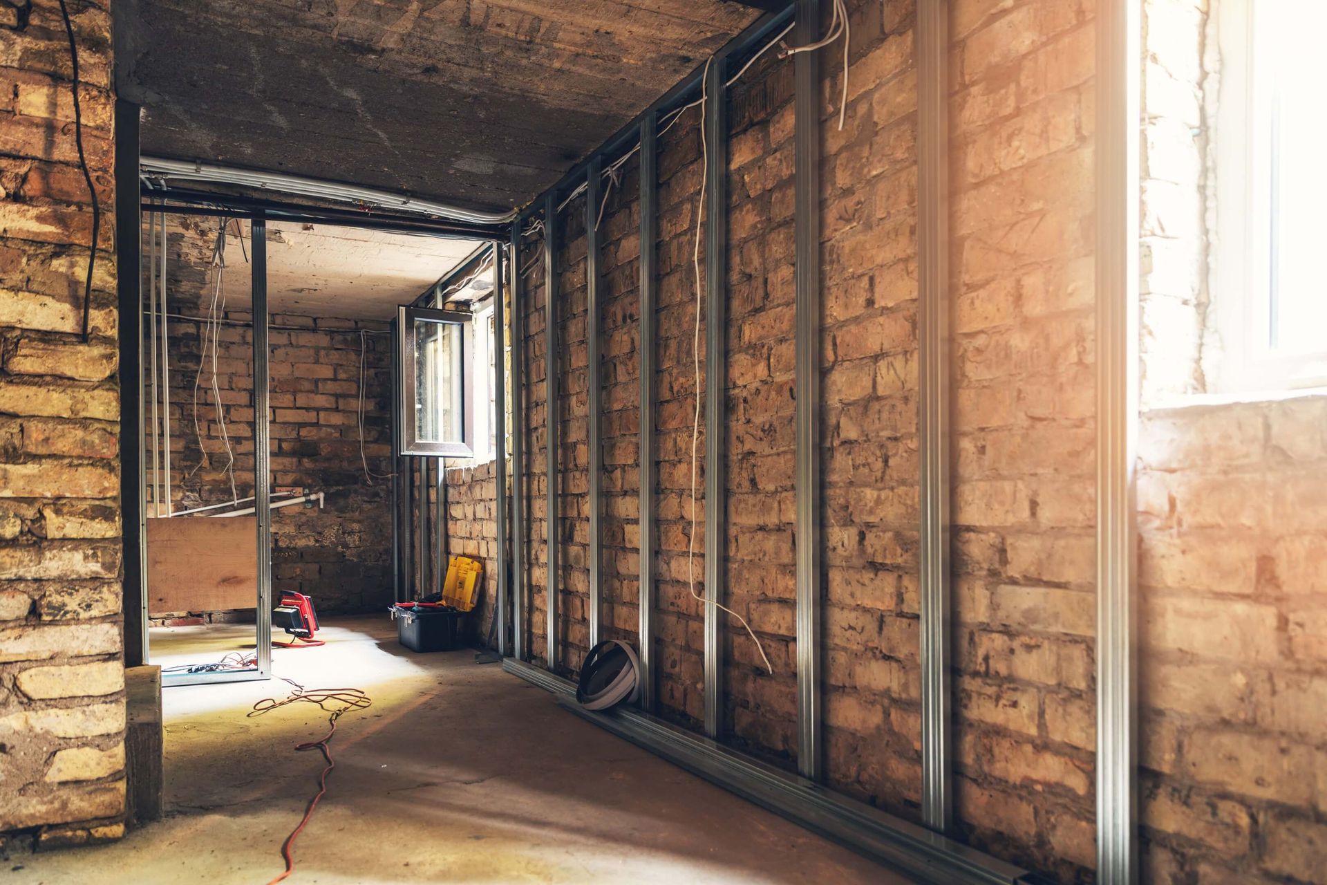 A corner of a room with a brick wall and a white door.