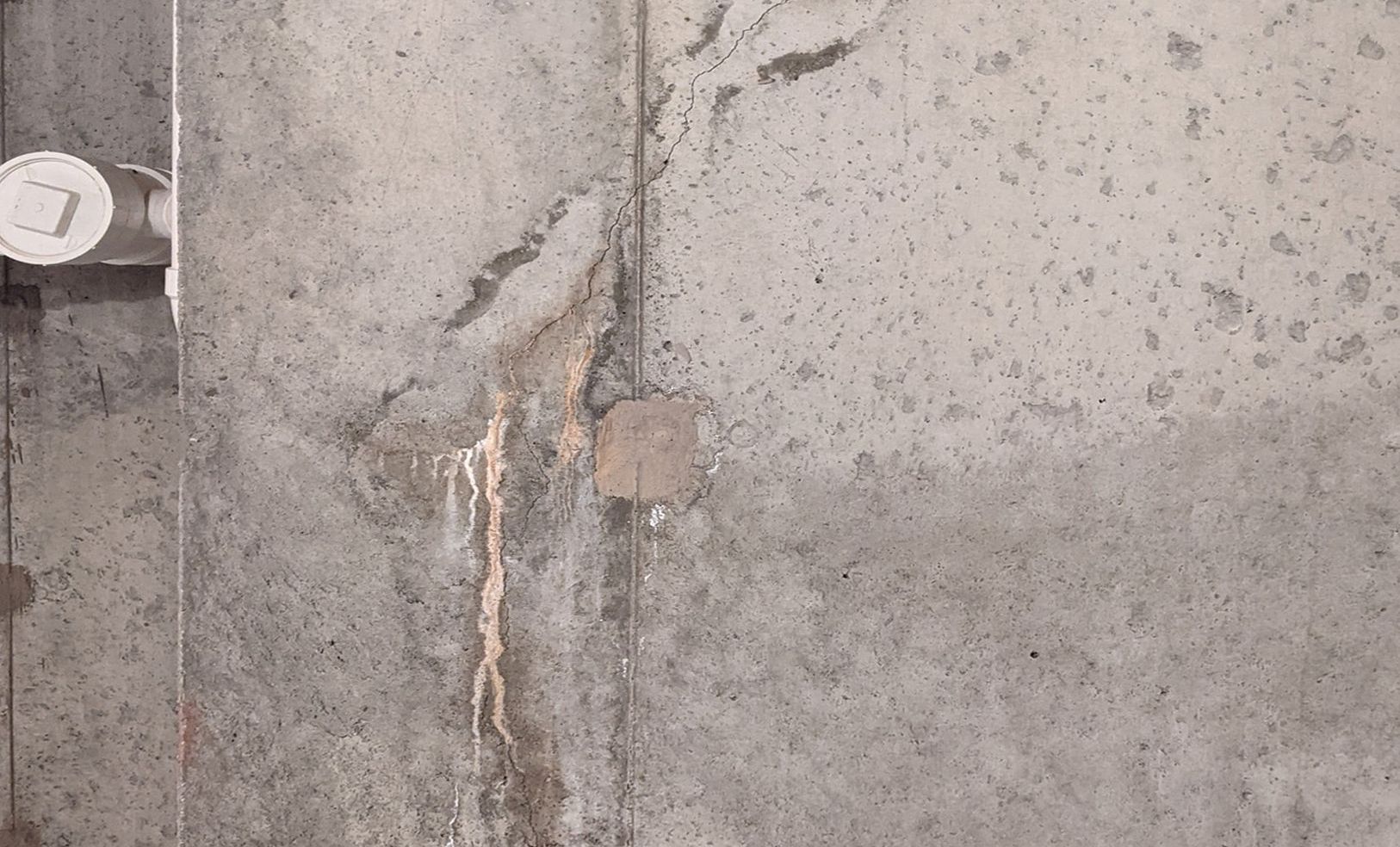 A close up of a concrete wall with a hole in it.