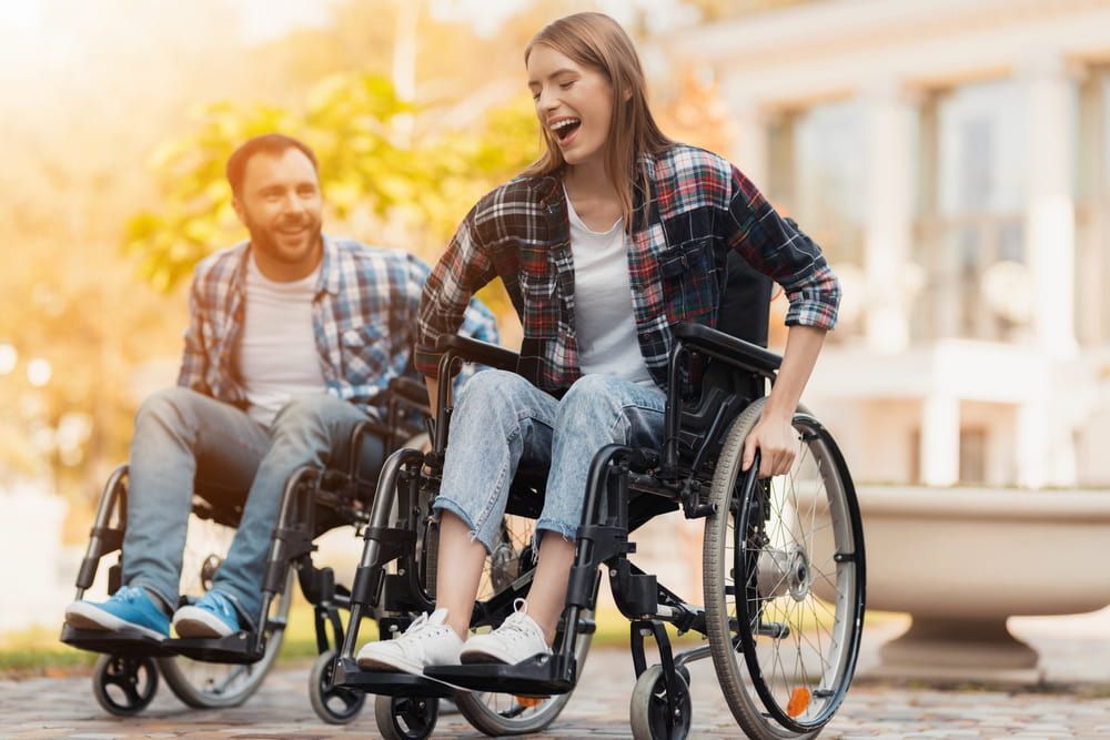 A Man and A Woman Are Sitting in Wheelchairs — VAL Disability Services in Taree, NSW