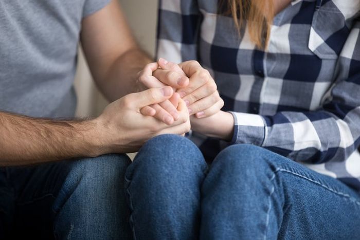 Married couple holding hands giving psychological support, close up view