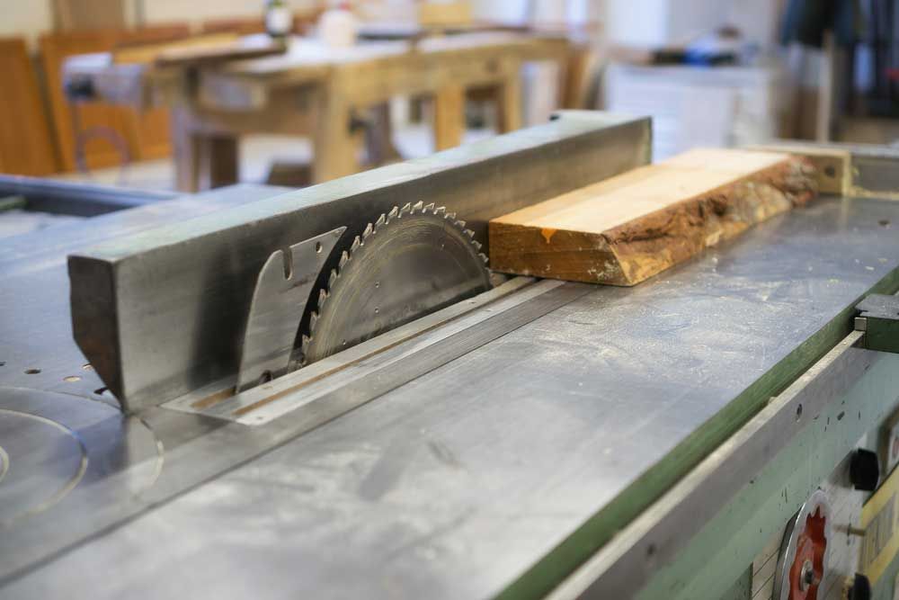 A circular saw is cutting a piece of wood.