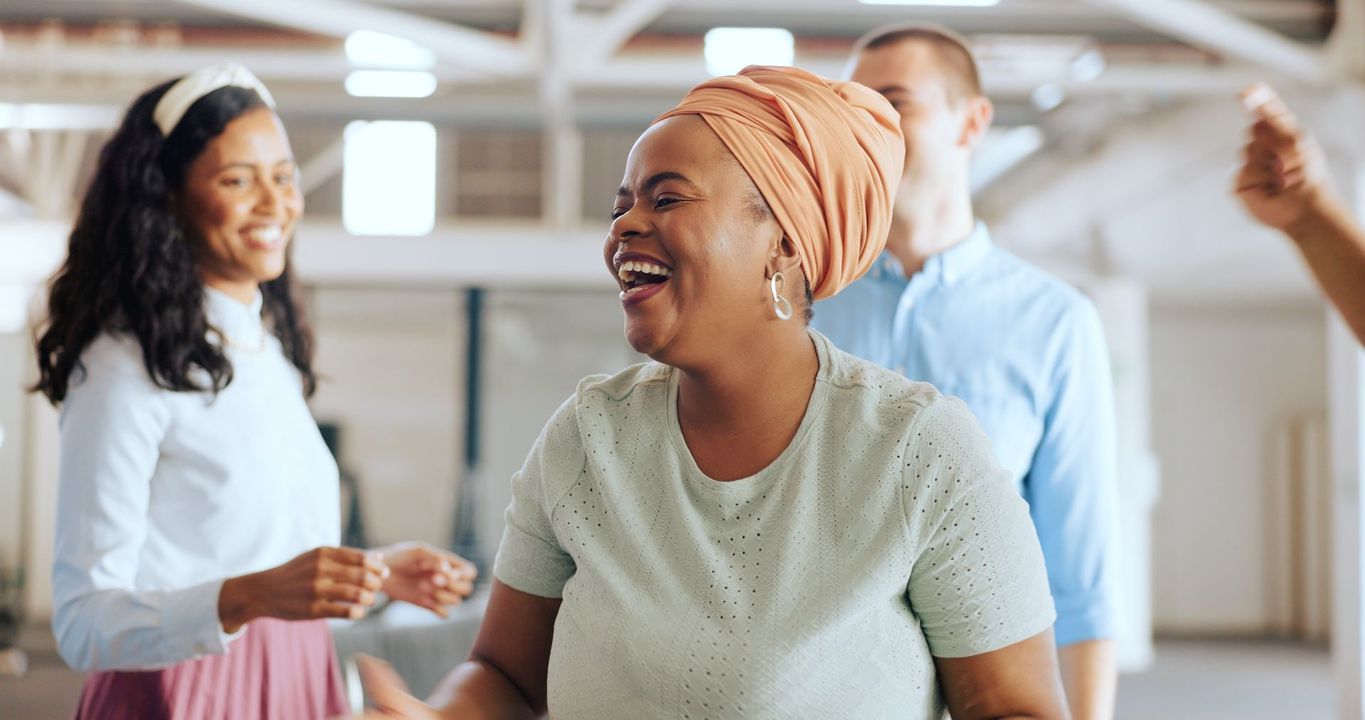 a group of people are standing next to each other in a room and laughing