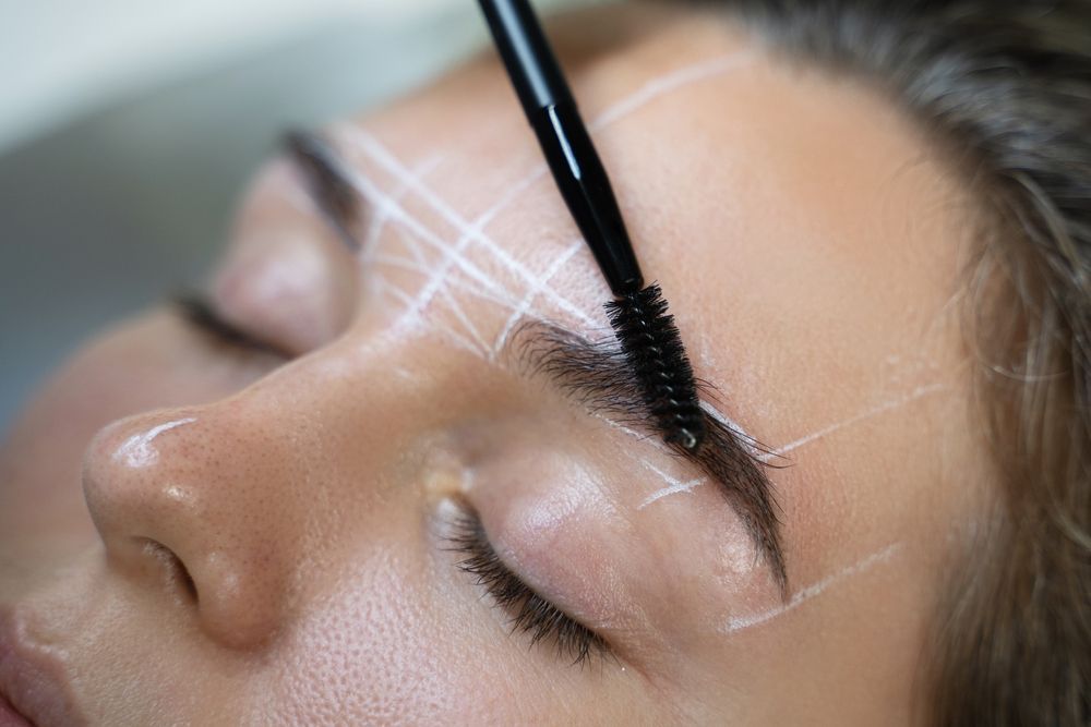 A woman is getting her eyebrows done in a beauty salon.