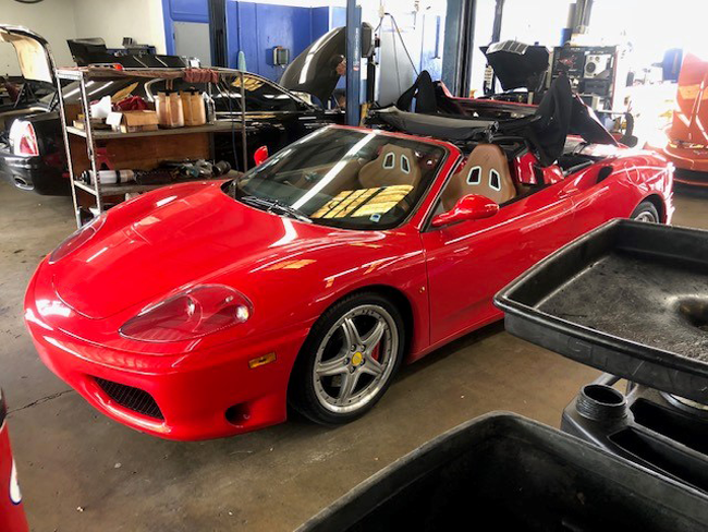 Red convertible Ferrari in a garage. | Madison Automotive