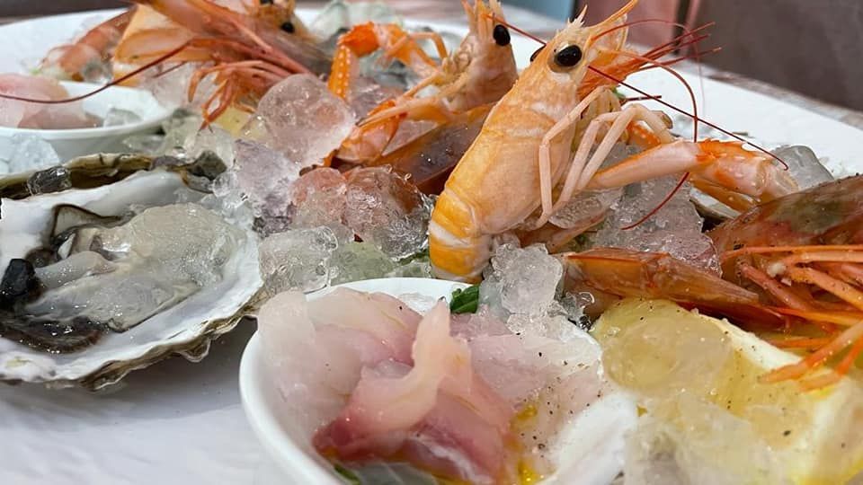 Ci sono molti tipi diversi di frutti di mare nel piatto.