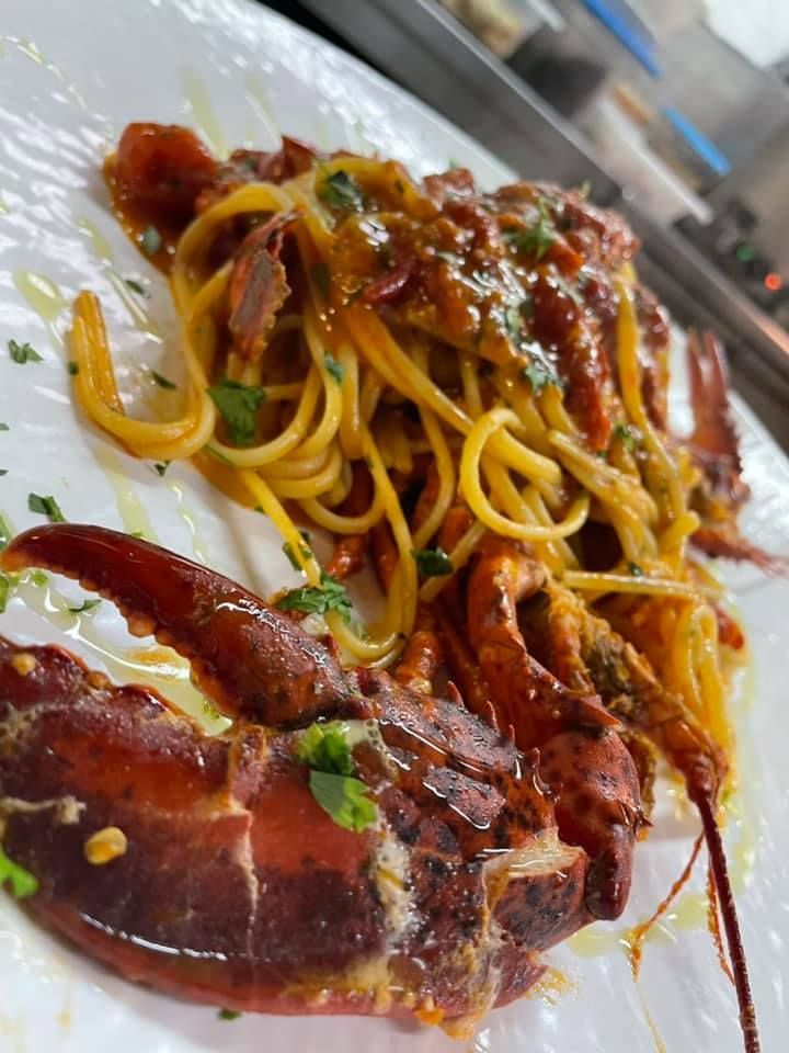 Un primo piano di un piatto di spaghetti e aragosta su un tavolo.