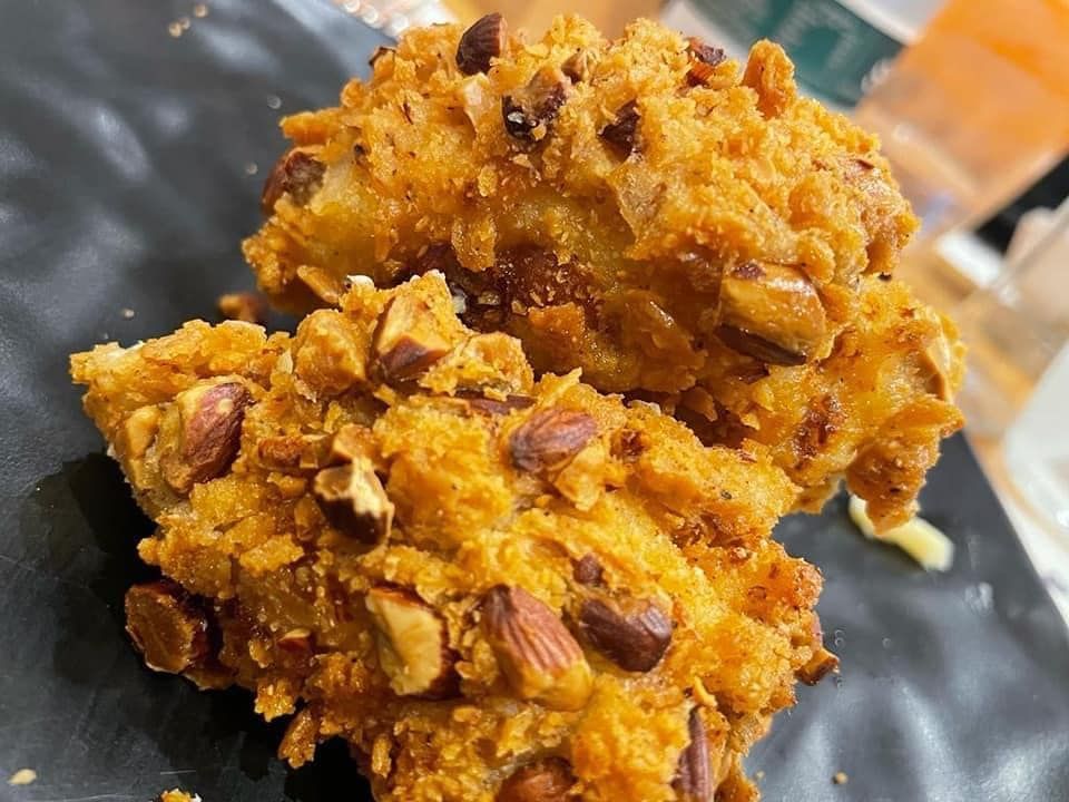 Un primo piano di un biscotto con noci su un piatto nero.