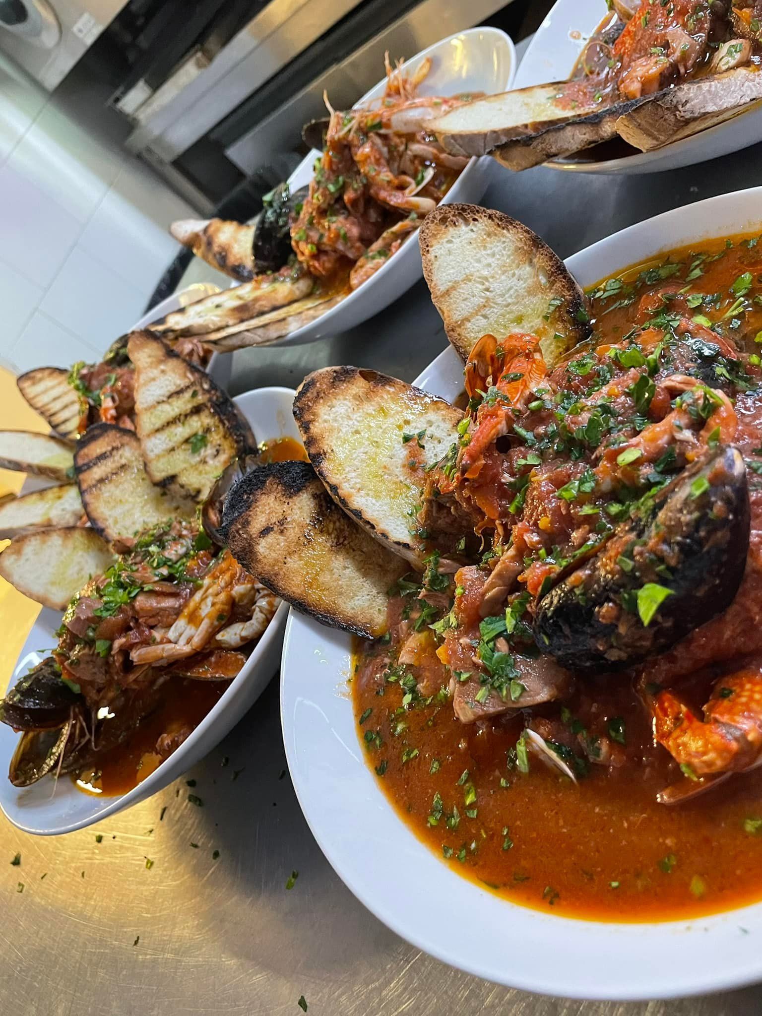 Un primo piano di una ciotola di zuppa con pane su un tavolo.