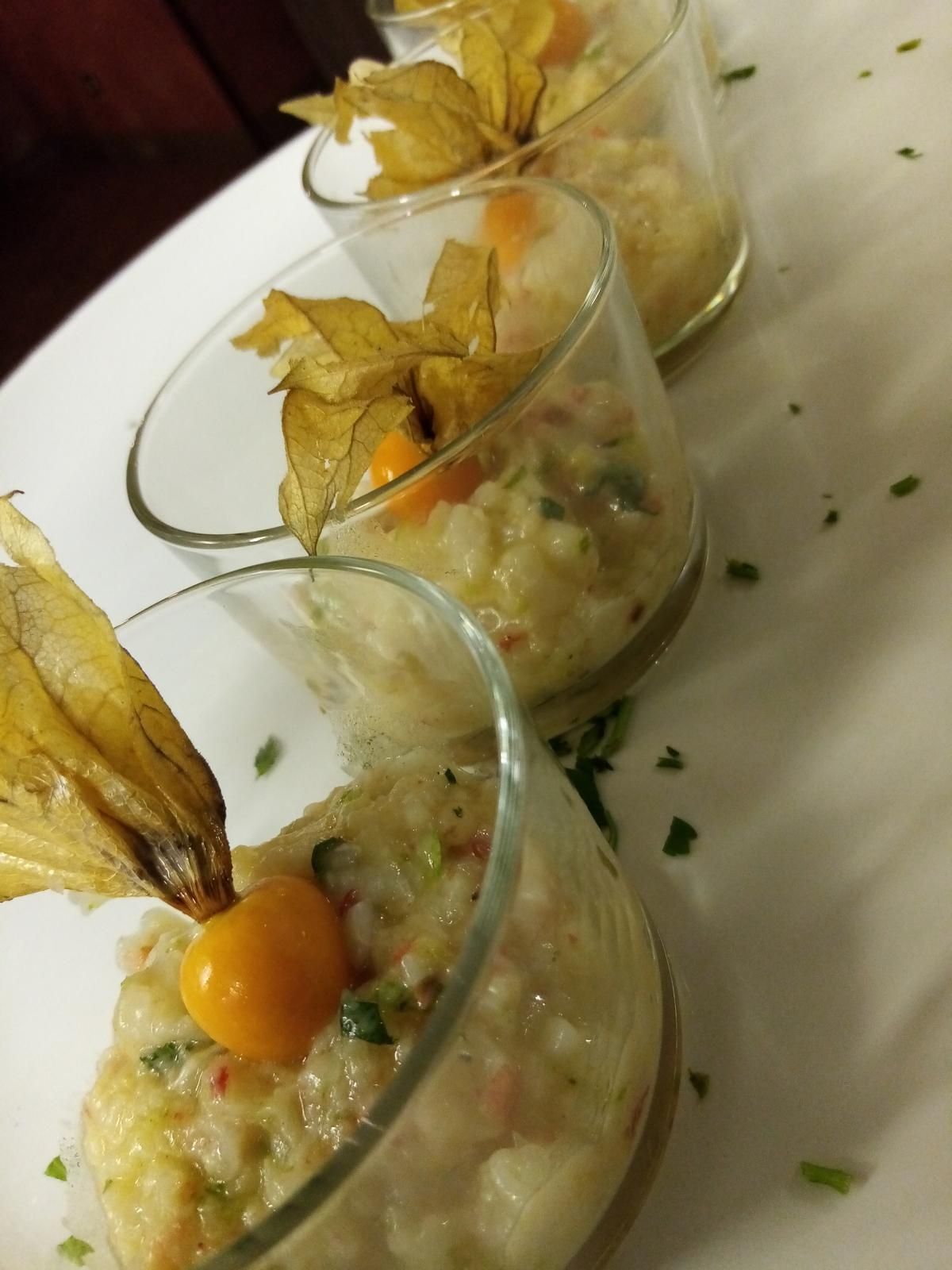 Una fila di bicchieri pieni di cibo su un piatto bianco