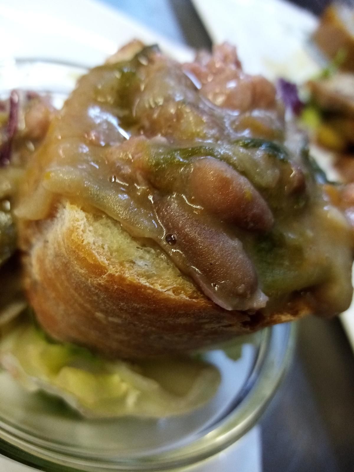 Un primo piano di un panino con fagioli e cipolle su un piatto