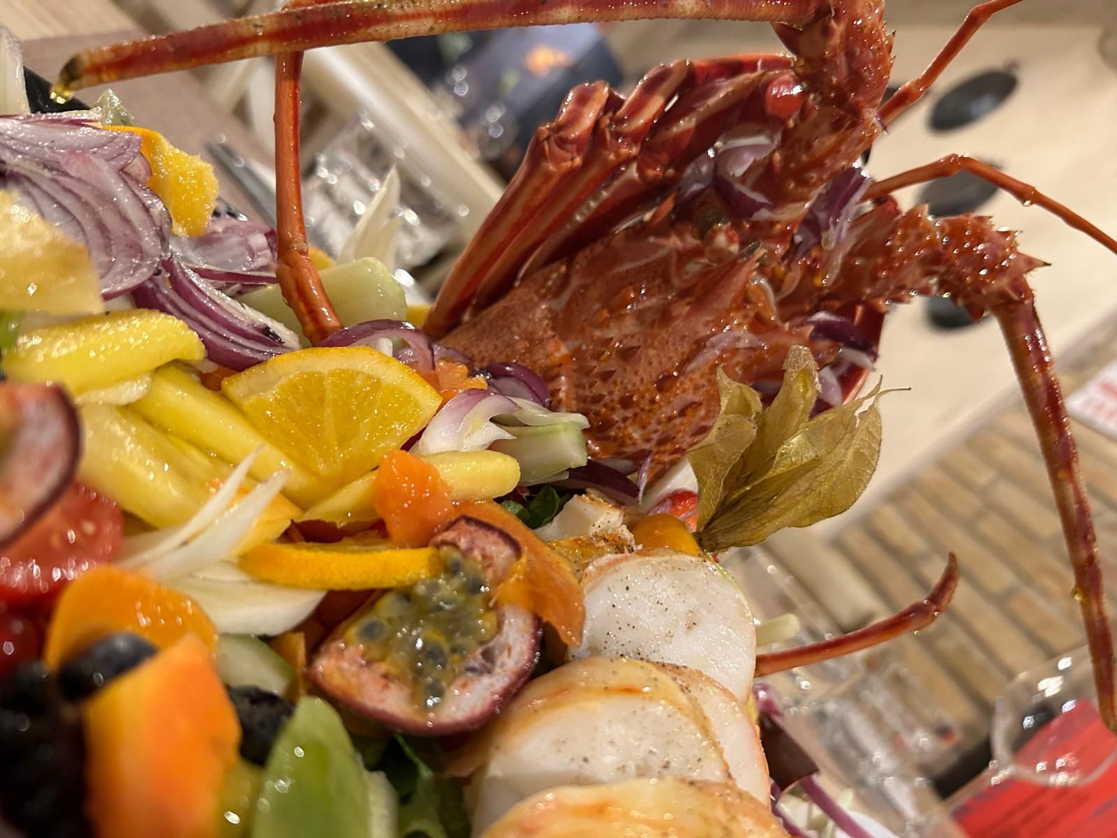 Un'aragosta è adagiata su un'insalata di verdure.