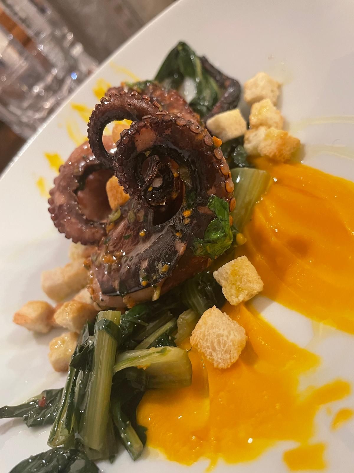 Un primo piano di un piatto di cibo con un polpo sopra