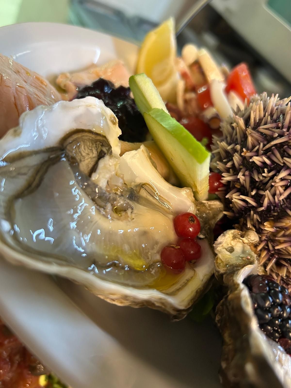 Un primo piano di un'ostrica con verdure su un piatto