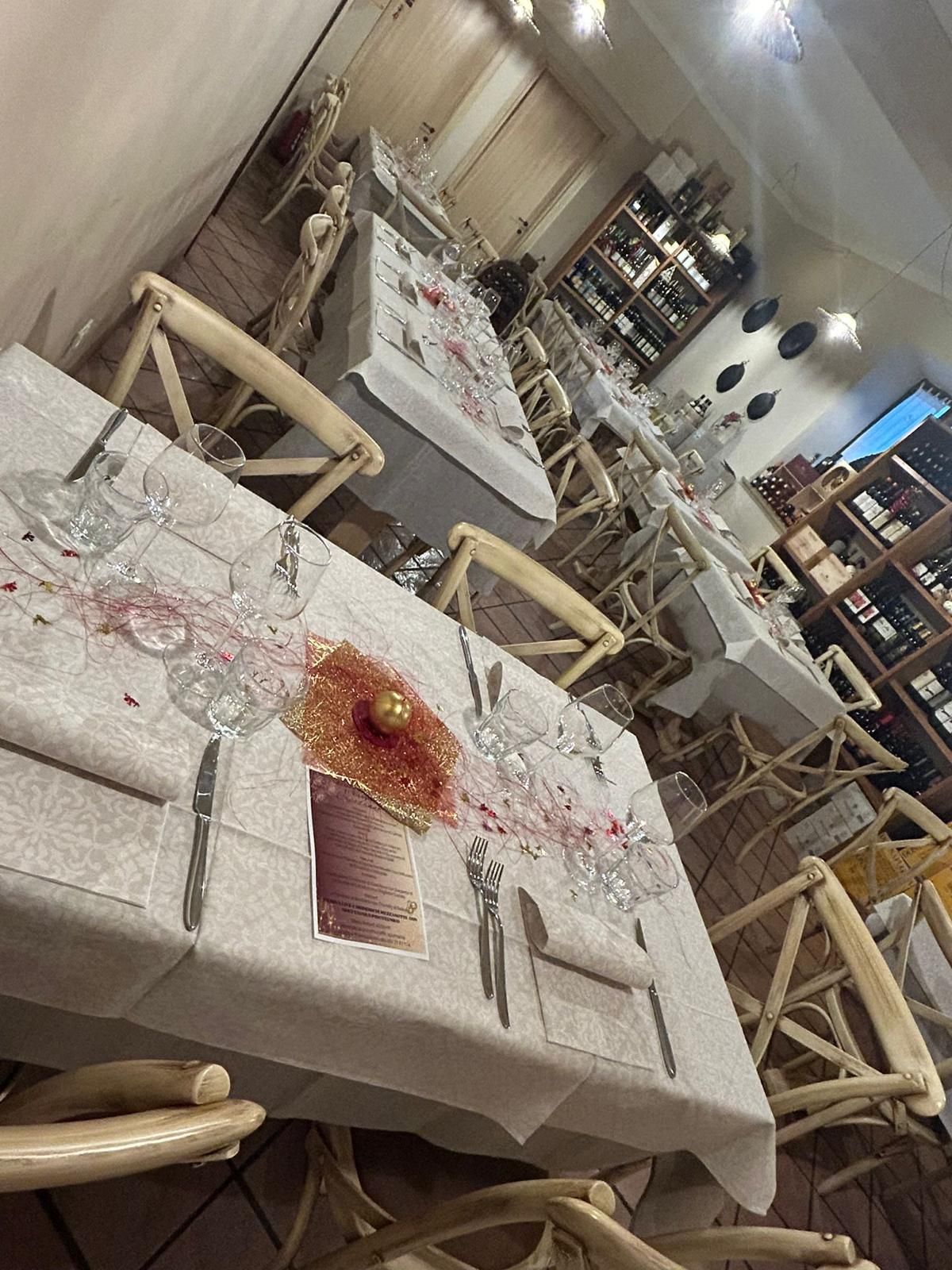 Un ristorante con tavoli e sedie allestiti per una cena.