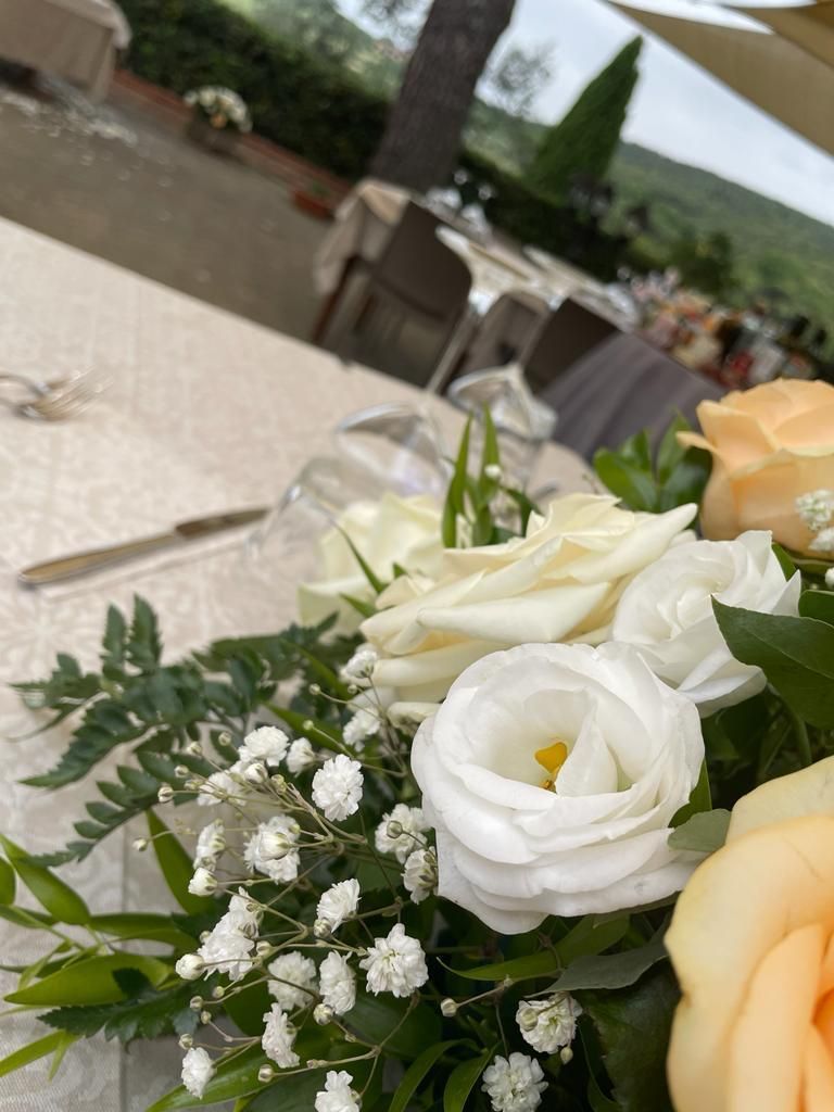 Un mazzo di rose bianche e gypsophila è su un tavolo.