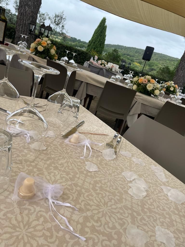 Un tavolo con bicchieri, utensili e fiori sopra.