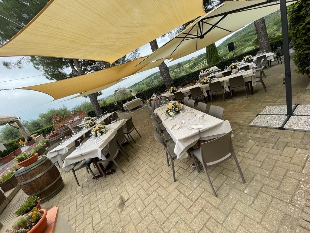 Un patio attrezzato con tavoli e sedie sotto gli ombrelloni.