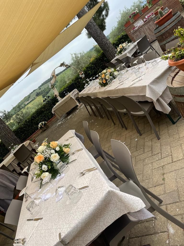Un patio con tavoli e sedie allestito per un ricevimento di nozze.