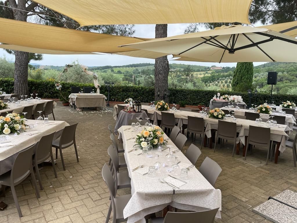 Un'ampia zona pranzo all'aperto con tavoli, sedie e ombrelloni.