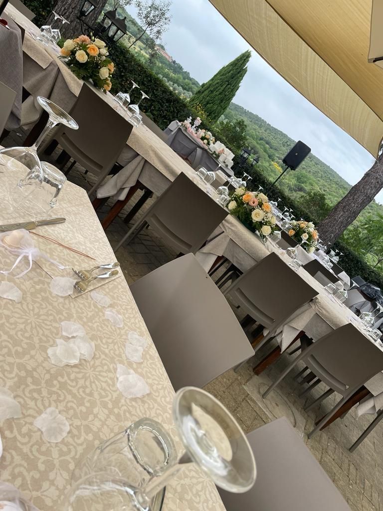 Un lungo tavolo con sopra un sacco di bicchieri e fiori.