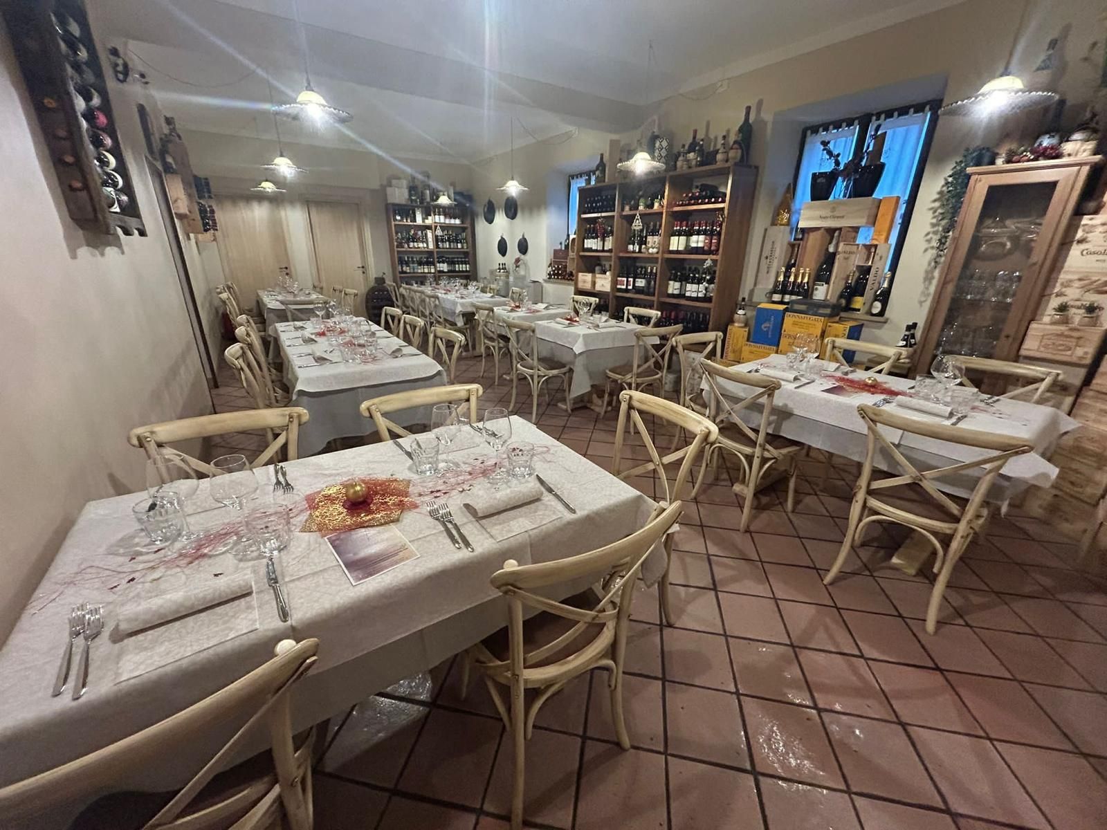 Un ristorante con tavoli e sedie allestiti per una cena.