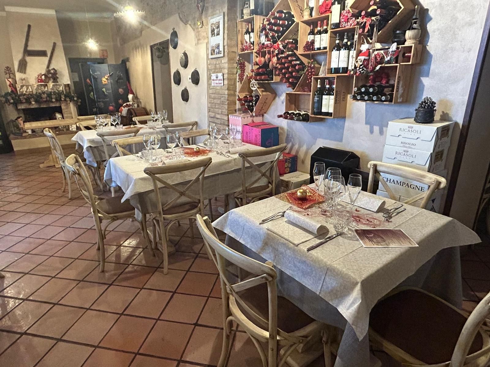 Un ristorante con tavoli, sedie e bottiglie di vino sugli scaffali.
