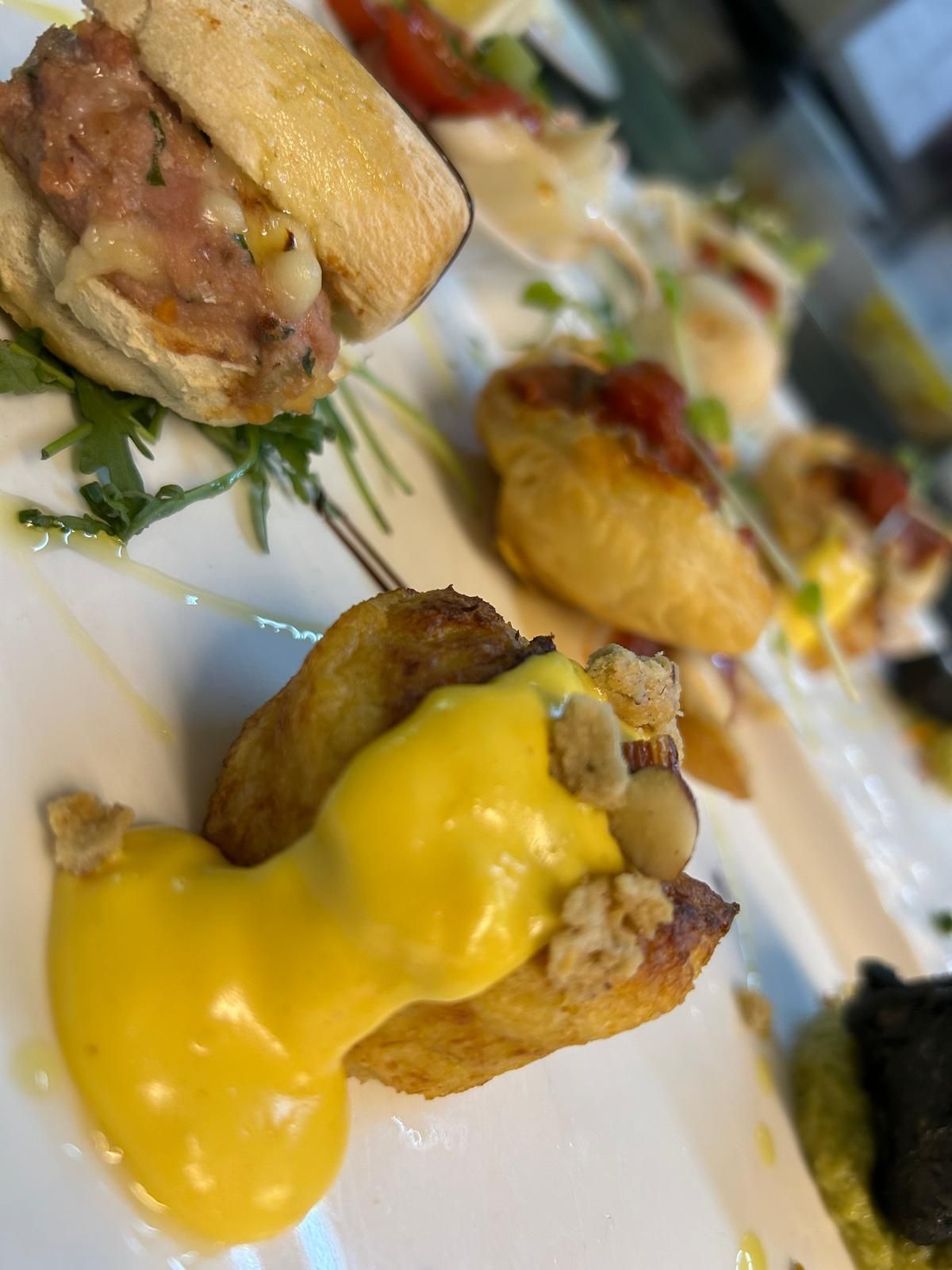 Un primo piano di un piatto di cibo con una salsa gialla sopra