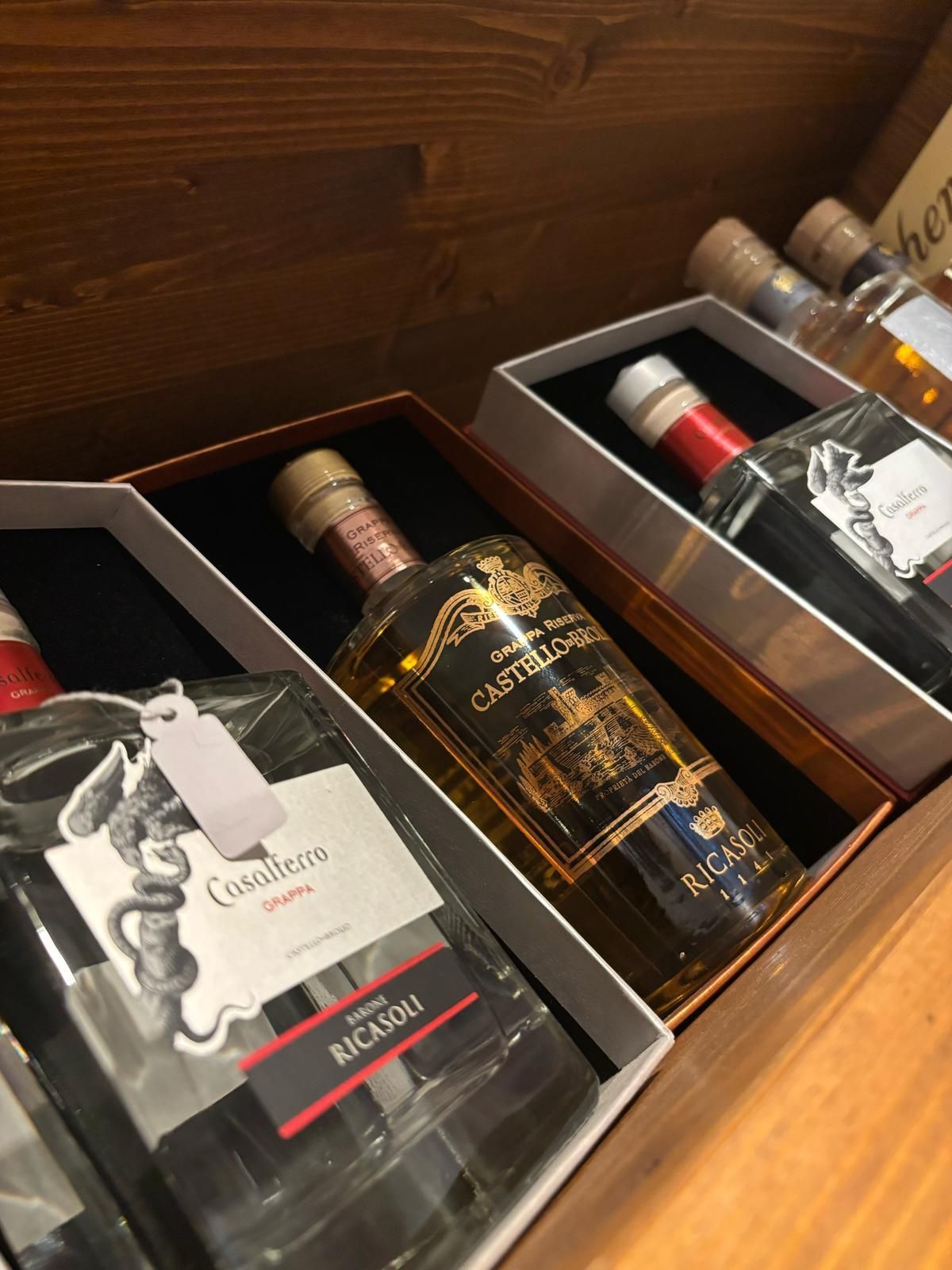 Tre bottiglie di liquore sono in scatole su un tavolo di legno